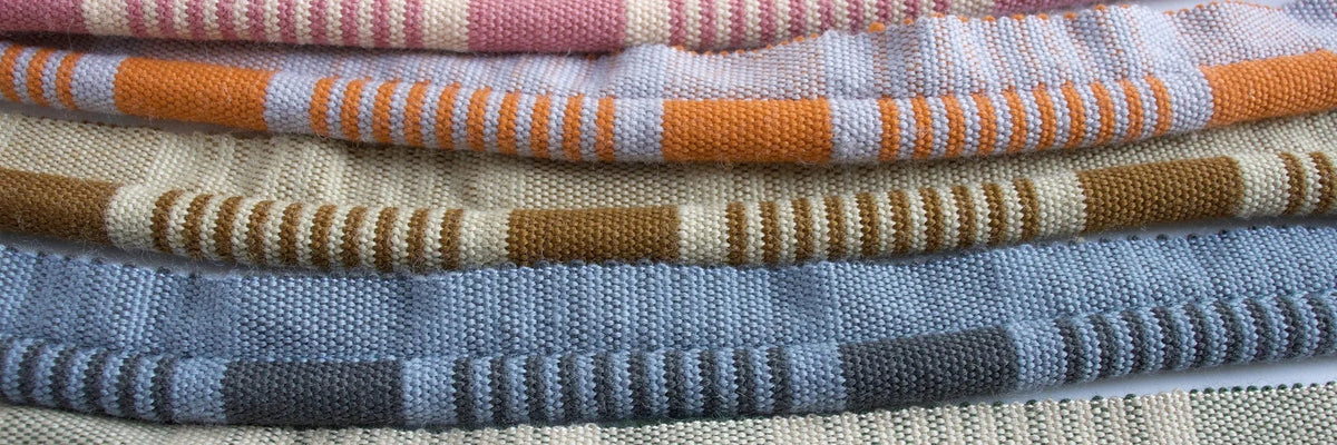 The Arundel Trimmings Collection by The Vale London, woven tapes stacked in pink, orange, ochre, blue and grey