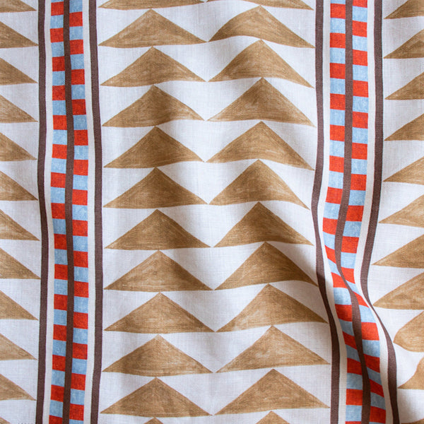 #dune Menkaure outdoor fabric in Dune, a large-scale geometric of tan triangles with red and blue banded stripes on cream
