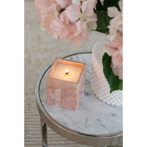 Rose Quartz Candle burning on a marble side table beside pink hydrangeas