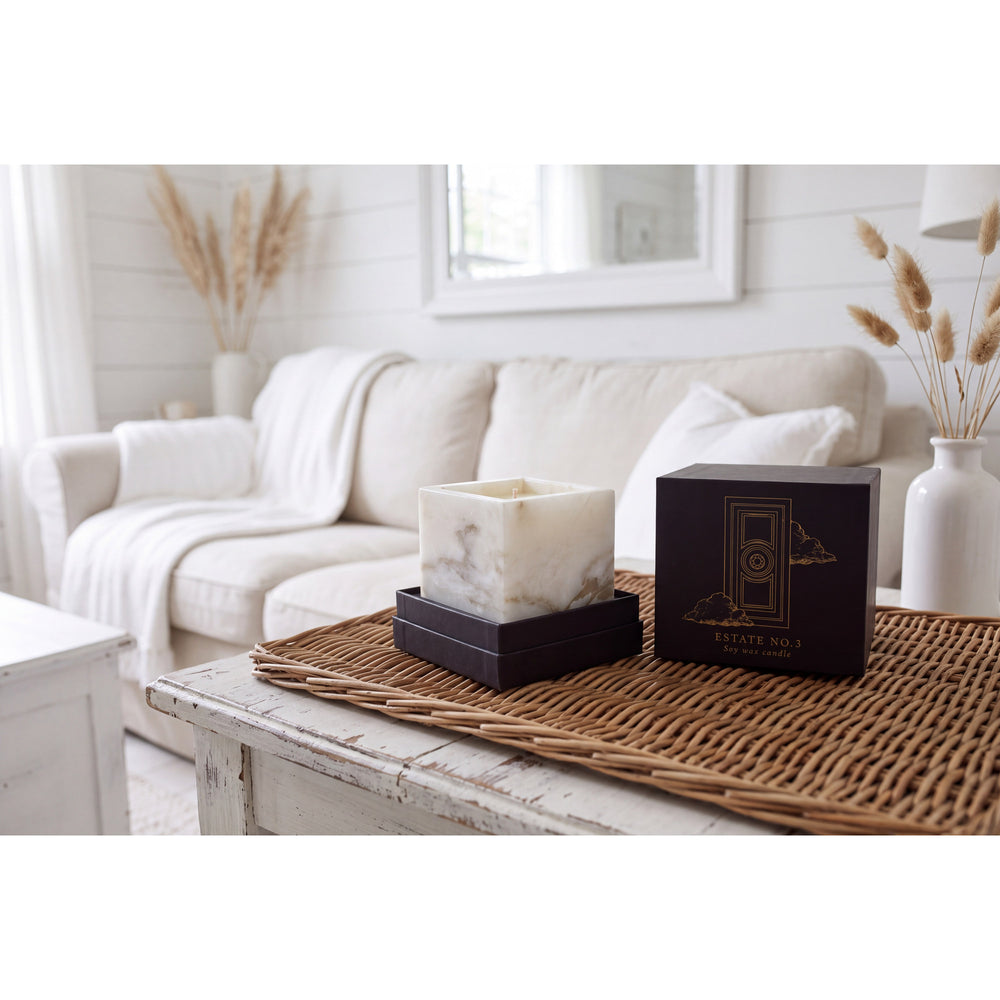 Travertine Candle in a natural beige marble vessel, shown against a white background