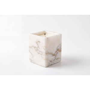 Travertine Candle in a natural beige marble vessel, shown against a white background