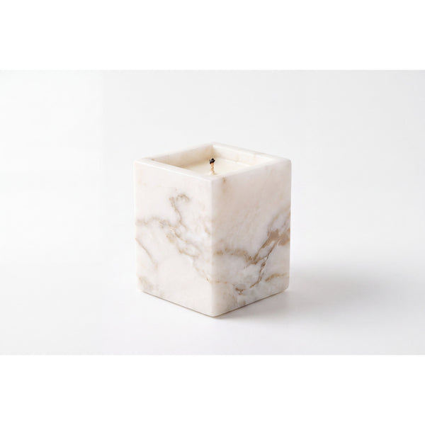 Travertine Candle in a natural beige marble vessel, shown against a white background